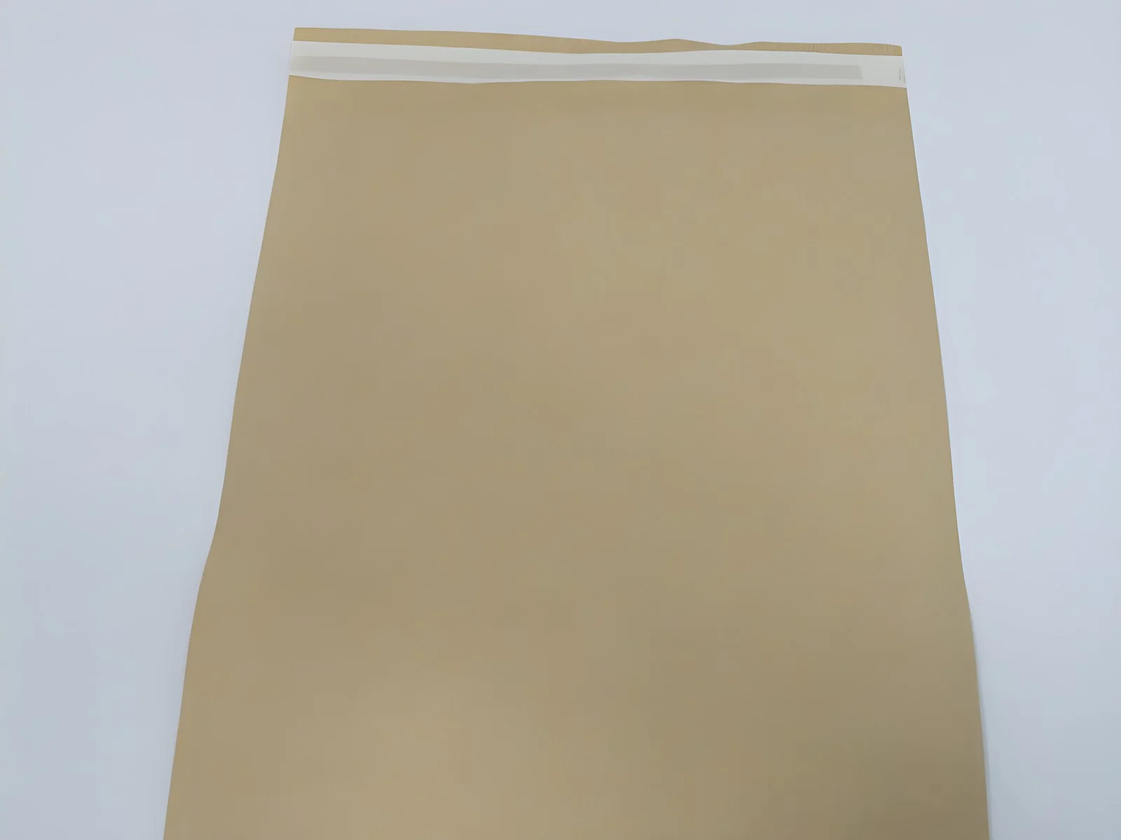 Haut d’une enveloppe en papier kraft, bande adhésive sous film de protection